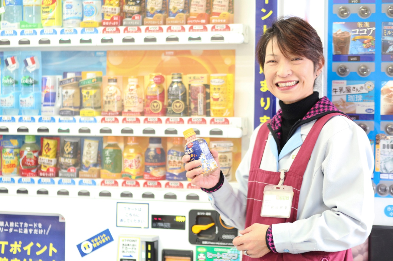 自動販売機で紅茶を買う秋山さん