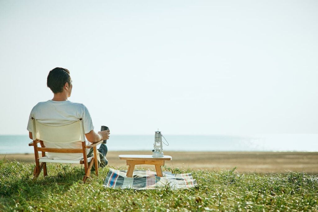 chabu tableと一緒に海辺で一人のんびり過ごす男性